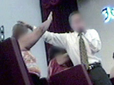 Imagen de un lider religioso de camisa y corbata dando ayuda espiritual a una fiel mediante imponerle las manos
